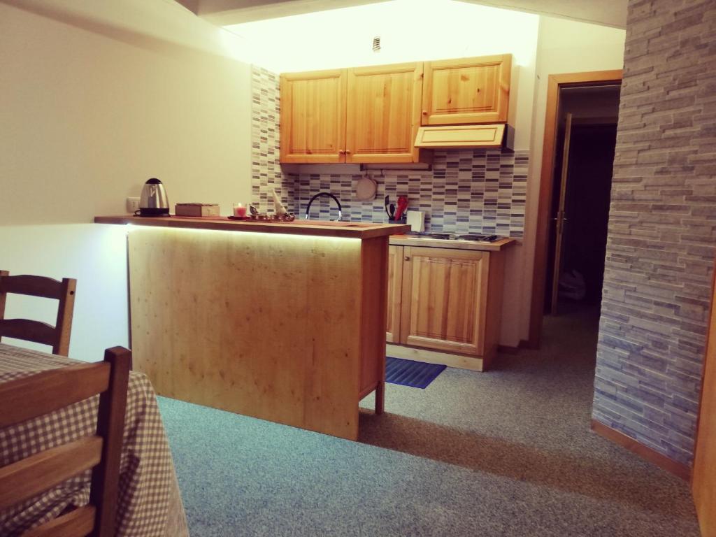 a kitchen with wooden cabinets and a counter top at Noemi Marilleva vacanze in Marilleva