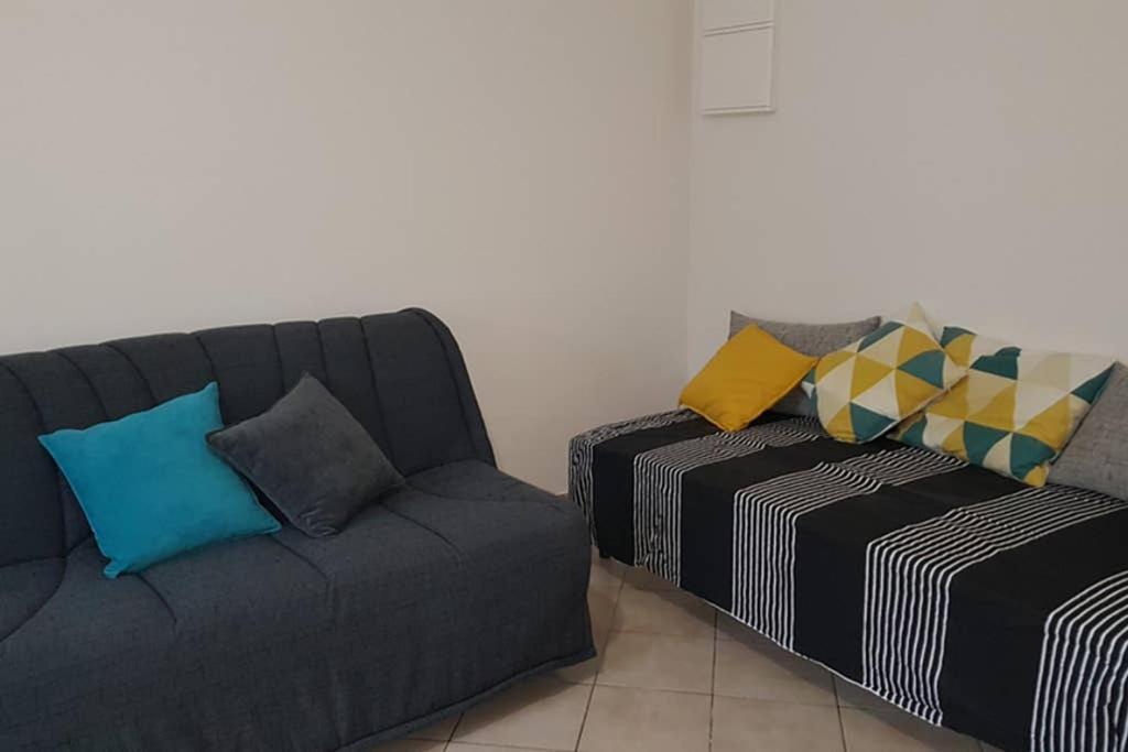 1 sofá y 1 silla en la sala de estar. en Giropode, maisonnette 36m2, 1/5 pers, cour fermée., en Chasseneuil-du-Poitou