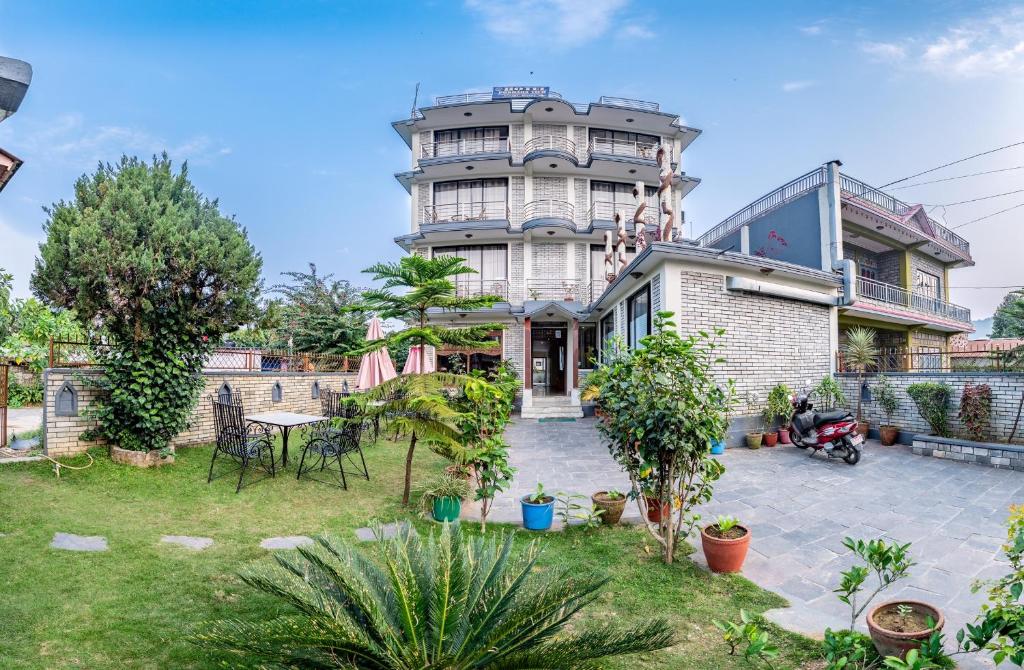 an apartment building with a courtyard in front of it at Hotel Pokhara View in Pokhara