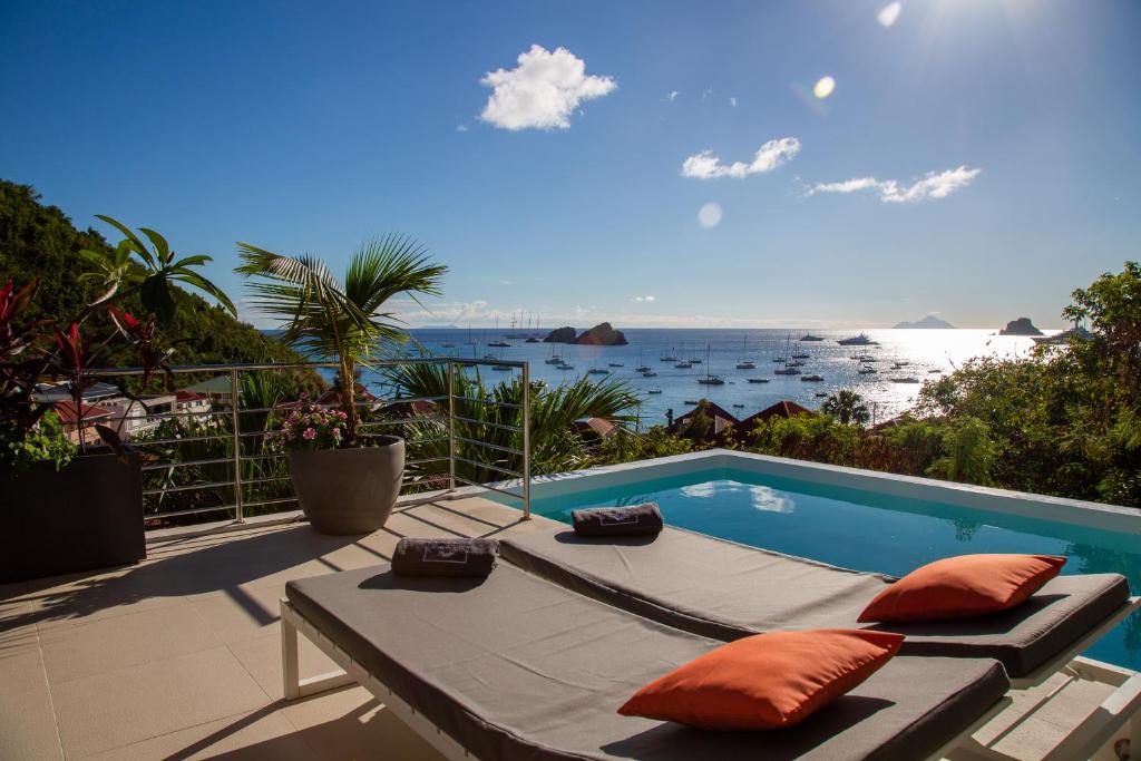 a patio with a pool and a view of the ocean at Villa AKA walking acces to beach in Saint Barthelemy