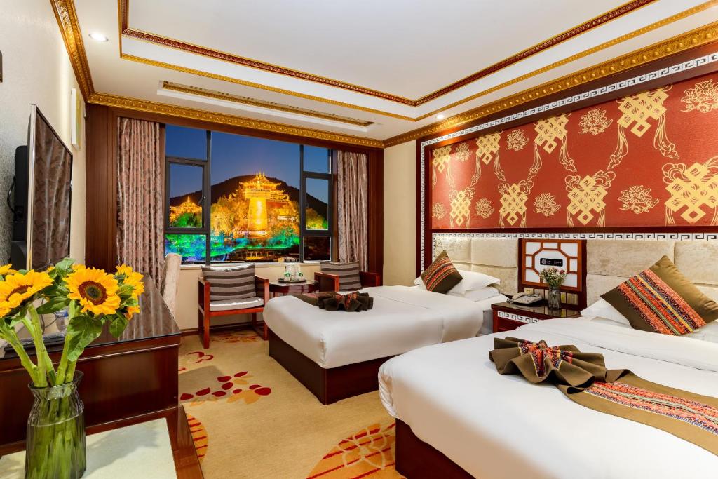 una camera d'albergo con due letti e una sala da pranzo di Floral Hotel · Shangri-la Blue Sky a Shangri-La