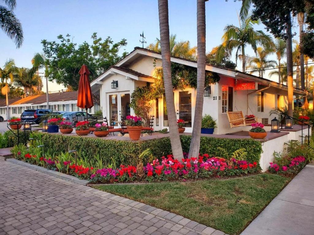 a white house with flowers in front of it at Marina Beach Motel in Santa Barbara