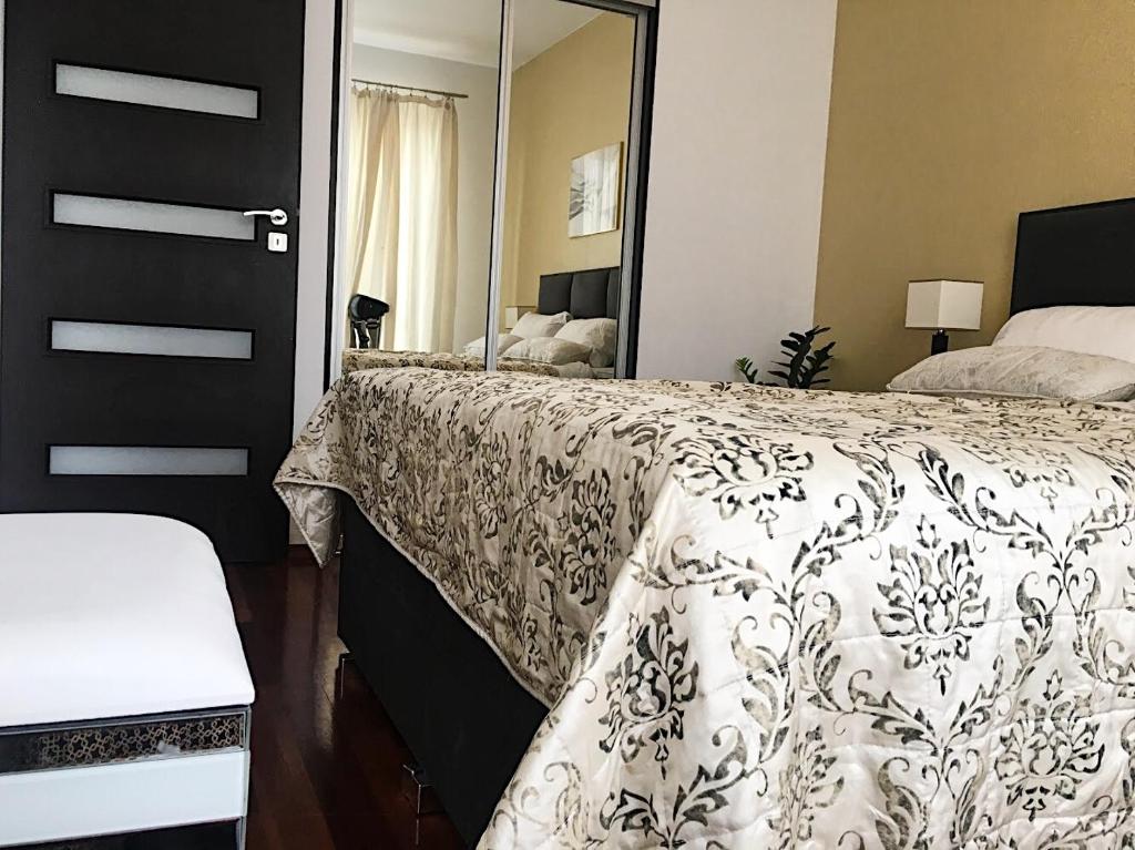 - une chambre avec un lit et un grand miroir dans l'établissement 100 sqm Luxury Apartment Wilanów, à Varsovie