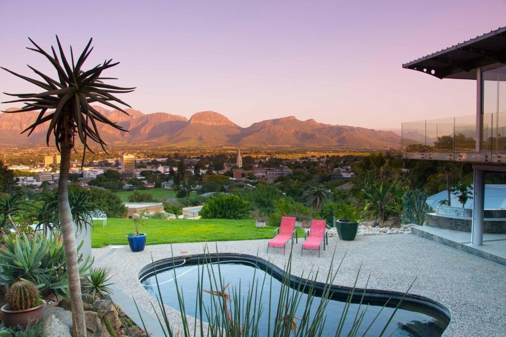 a patio with pink chairs and a view of the mountains at Beds@Paarl in Paarl