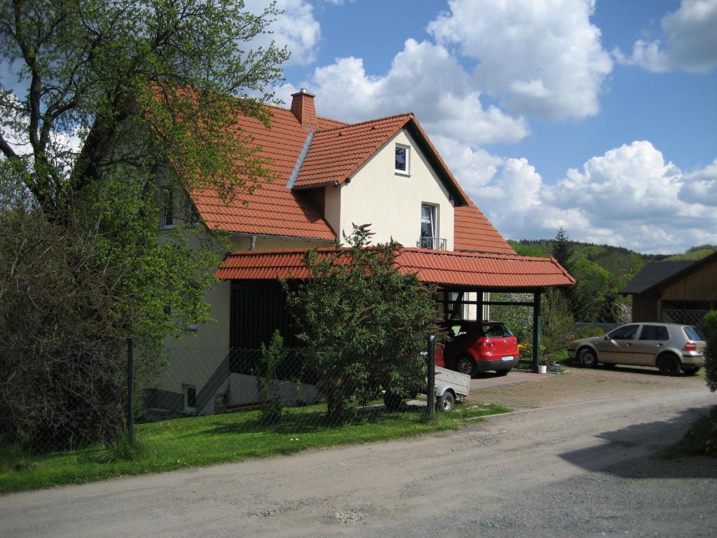 ein Haus mit einem orangenen Dach und einem Parkplatz in der Unterkunft Bismarckhöhe Tharandt in Tharandt