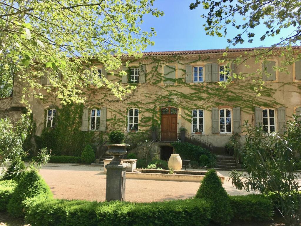 ein großes Steinhaus mit einem Brunnen davor in der Unterkunft B&B Maison d'Hôtes - Château de Jouques in Gémenos