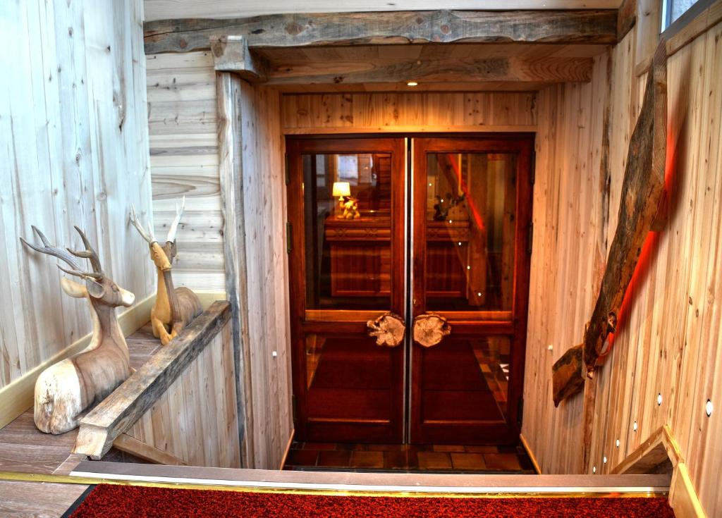 une porte dans une pièce avec des têtes de cerfs sur le mur dans l'établissement Hôtel Serre Palas, à Les Deux Alpes