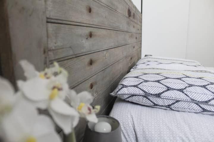 Schlafzimmer mit einem Bett mit einem Kopfteil aus Holz in der Unterkunft Appartement de charme bord de Loire in Saumur