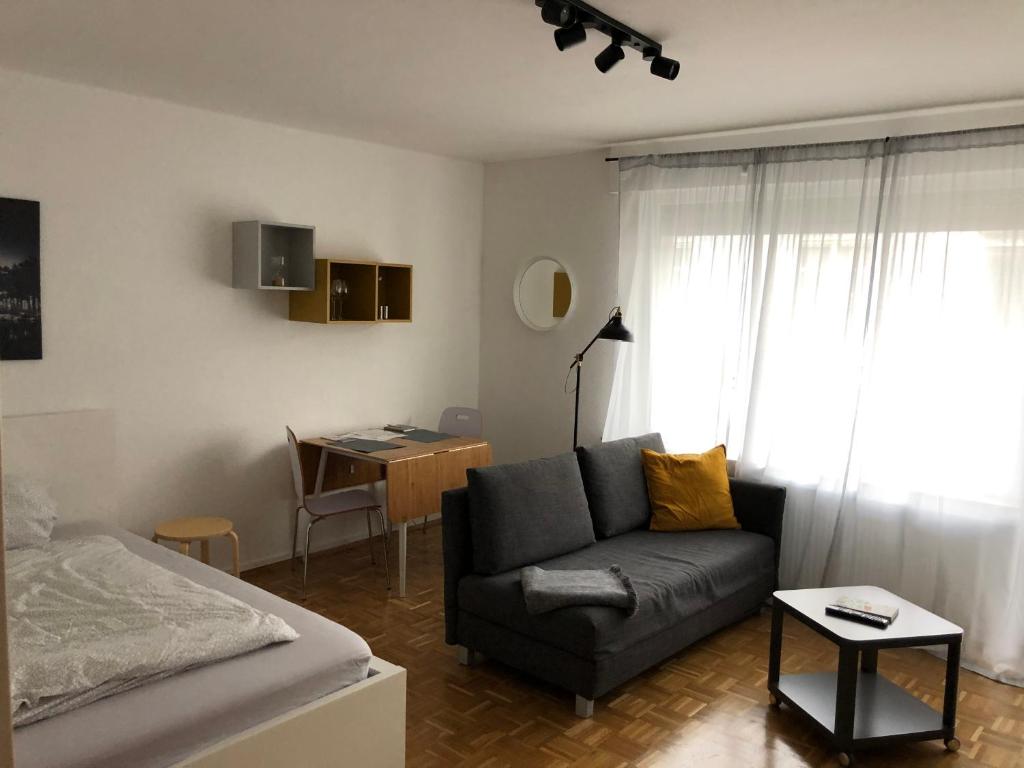 a living room with a couch and a bed and a desk at Zentrales Studio im Kaiserviertel in Dortmund