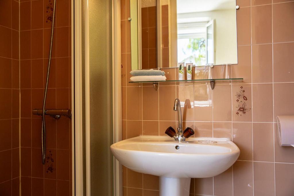 a bathroom with a sink and a mirror at Hôtel Du Soleil in Saint-Raphaël