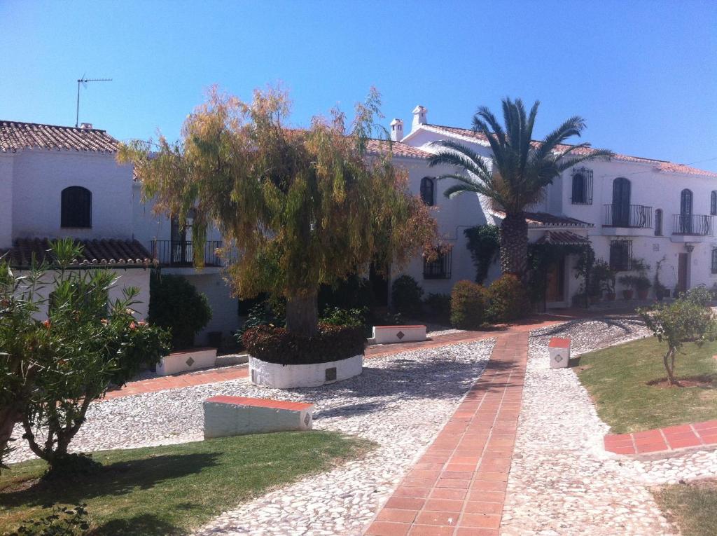 a large white house with trees in the yard at El Capistrano Sur in Nerja