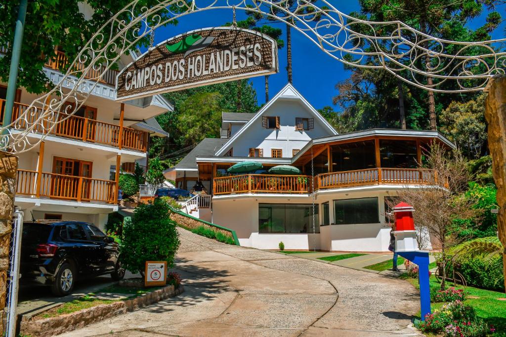 une maison avec un panneau devant elle dans l'établissement Pousada Campos dos Holandeses - Campos do Jordao, à Campos do Jordão