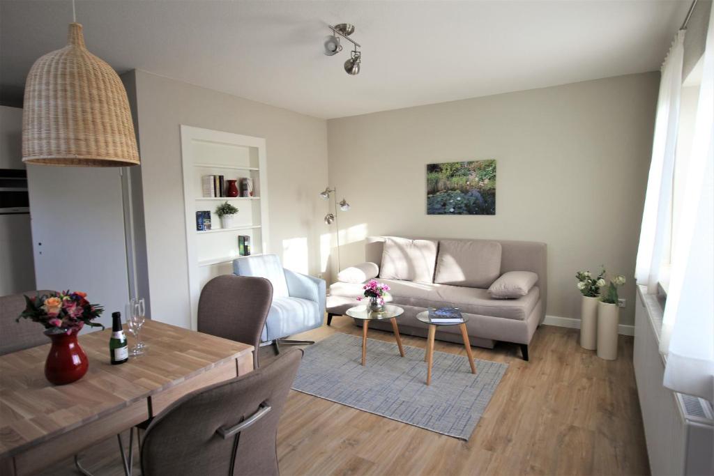 uma sala de estar com um sofá e uma mesa em Stadtwohnung zur großen Buche em Leer