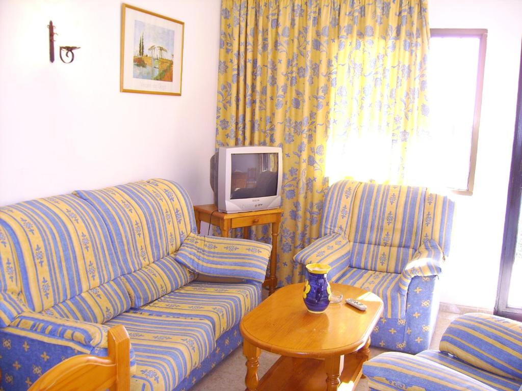 a living room with two couches and a tv at El Capistrano Sur in Nerja