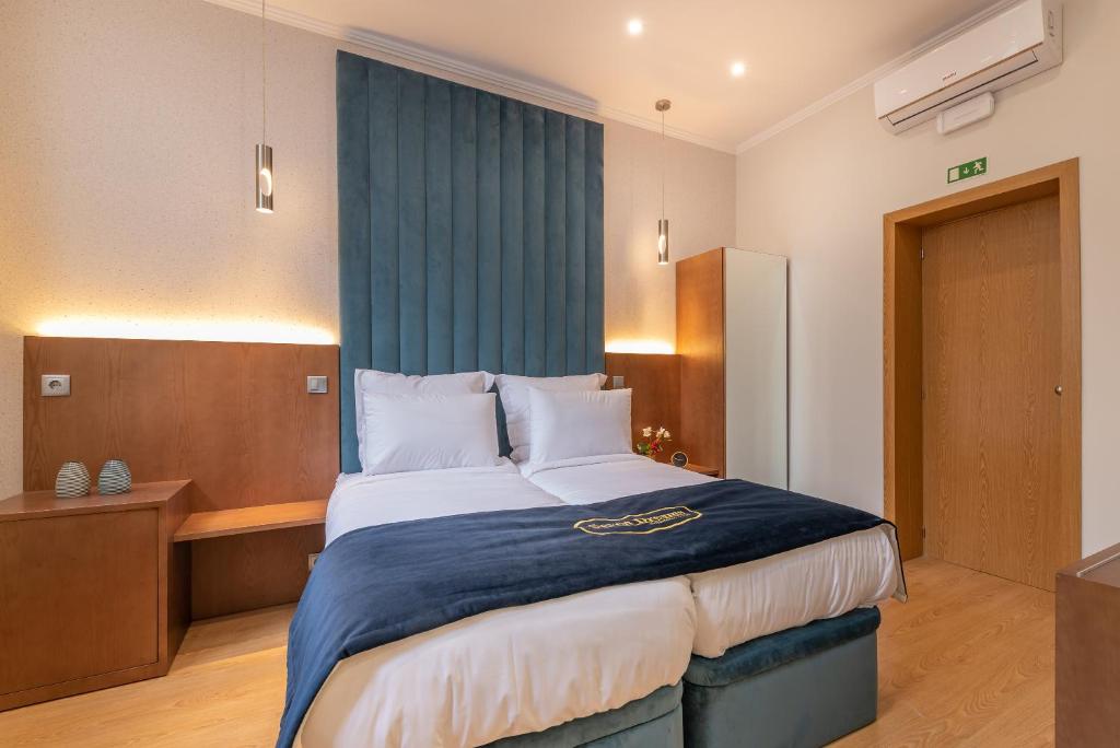 a bedroom with a large bed with a blue blanket at Seven Dreams Suites in Lisbon