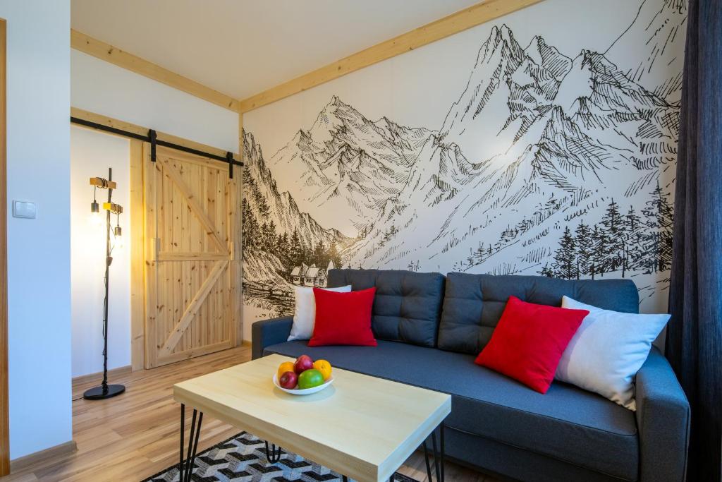 a living room with a blue couch and a table at Villa Granit Zakopane Centrum in Zakopane