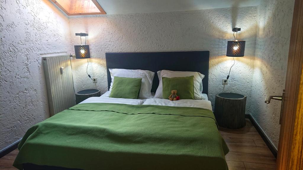 a bedroom with a large green bed with two lamps at Arber Apartments - Zwieslerwaldhaus in Lindberg