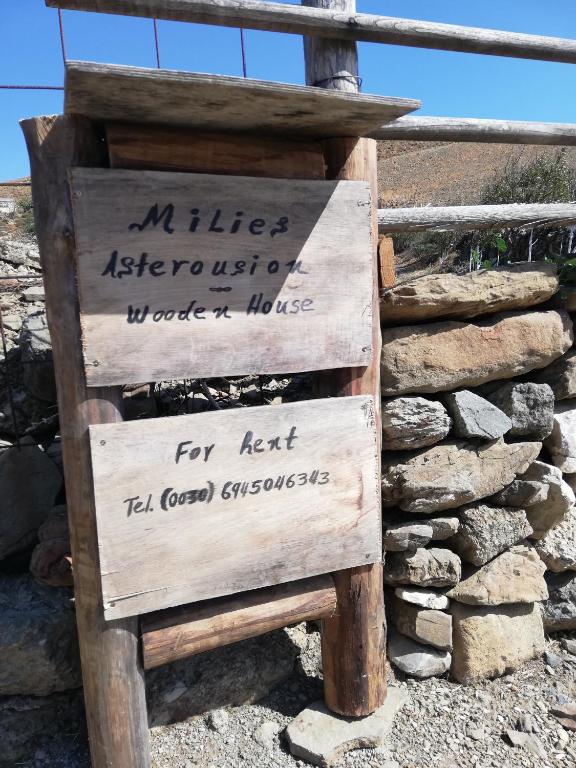 a wooden sign sitting next to a pile of rocks at Wooden House at the Mountain-private in Paránimfoi