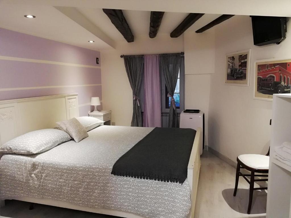 a bedroom with a large bed and a purple wall at Palazzo Sant'Elia in Caltagirone