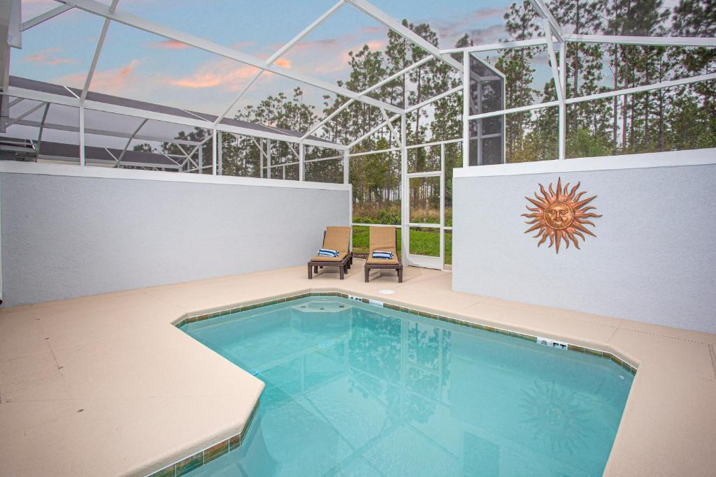 a large swimming pool in a building with a ceiling at Marvelous 4 Bd w/ Pool Close to Disney 218 in Kissimmee