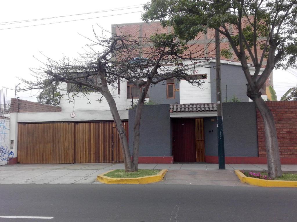 two trees on a sidewalk in front of a building at Habitación amoblada en Surco, Lima, Peru in Lima