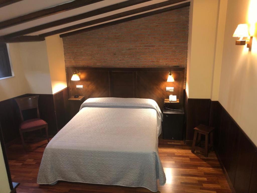 een slaapkamer met een wit bed in een kamer bij Hosteria Casa Vallejo in Salamanca