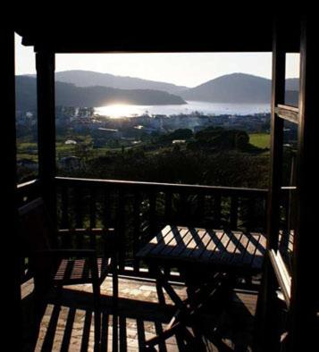 un banco en un balcón con vistas a la ciudad en Hostal Meson Leira Antiga, en Cedeira