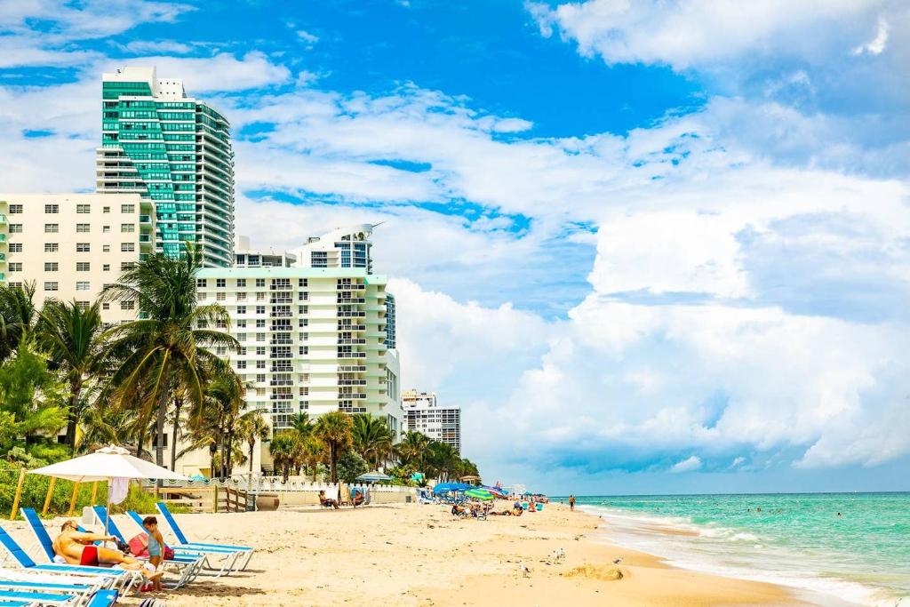 uma praia com cadeiras e guarda-sóis e edifícios em Paradise on Hollywood Beach 2 bed 2 bath em Hollywood