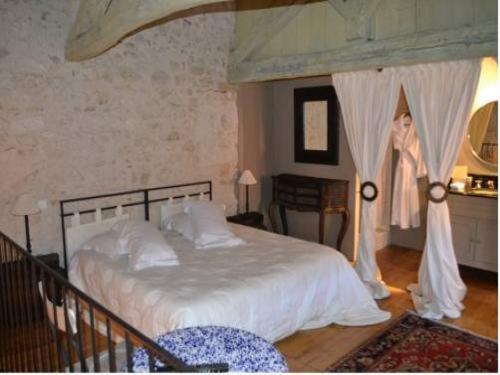 a bedroom with a large bed with a canopy at Appart's Village Trama Loges in Puymirol