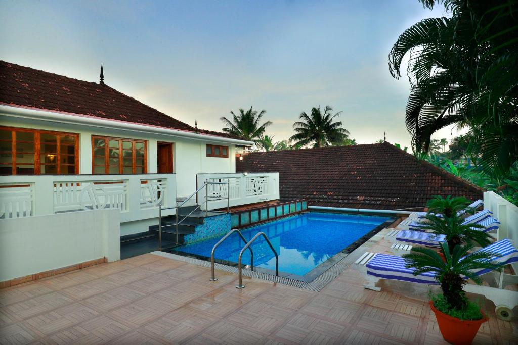 a house with a swimming pool in front of a house at Triveny River Palace in Alleppey