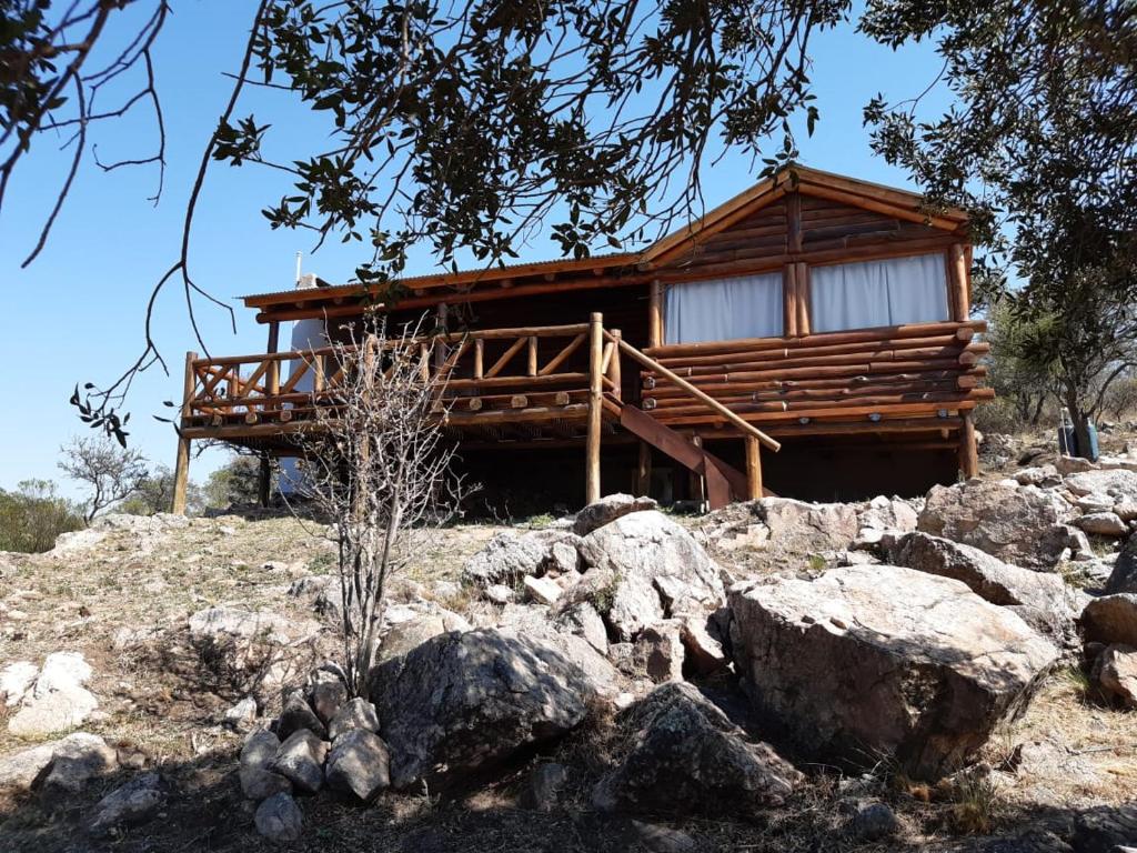 una cabaña de madera en la cima de una colina con rocas en Cabaña de Montaña, La Casita Mina Clavero CBA en Mina Clavero