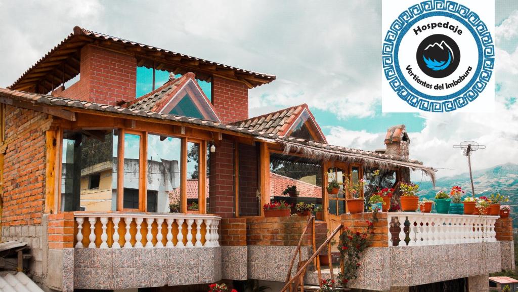 a model of a house with a sign in the background at Hospedaje Vertientes del Imbabura in Otavalo