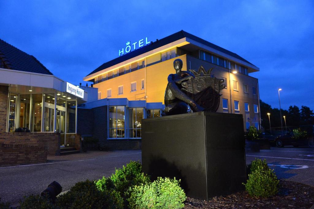 a building with a statue in front of it at Hotel De Zoete Inval Haarlemmerliede in Haarlem