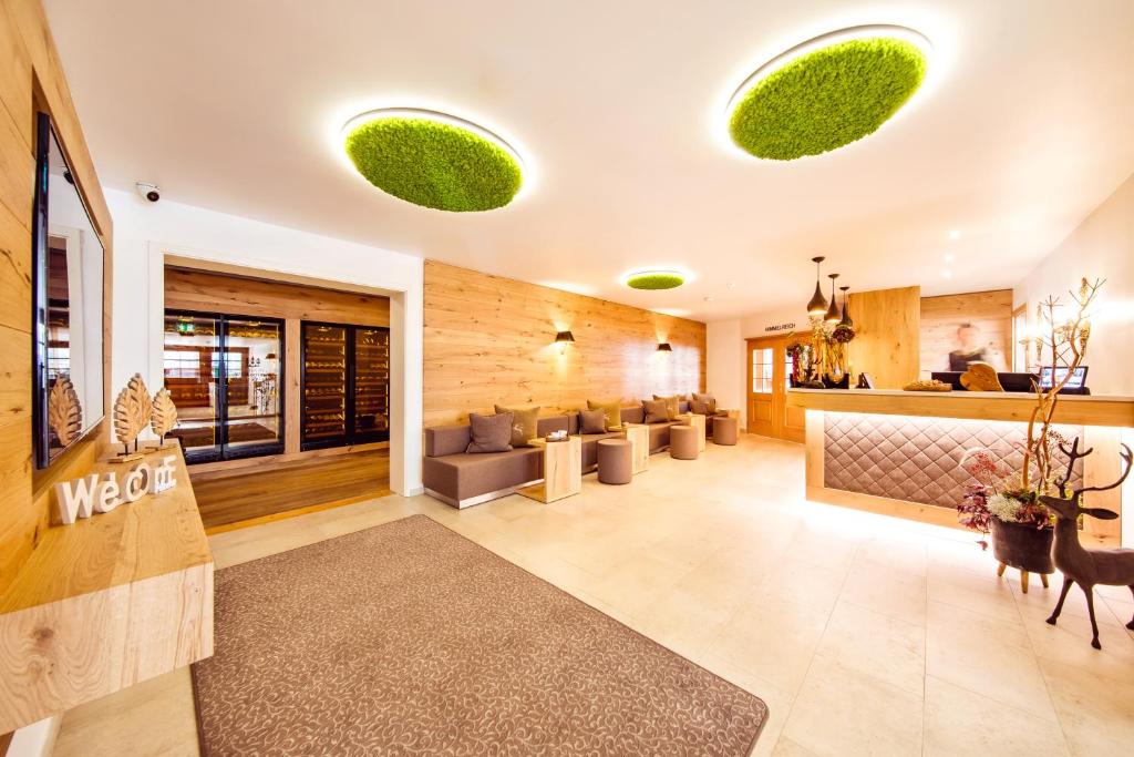 eine Lobby eines Hotels mit Sofas und Pflanzen an den Decken in der Unterkunft Landgasthof Hotel Gentner in Nürnberg