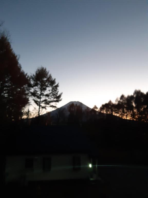 a silhouette of a mountain with a tree in the background at C.T.Forest in Oshino