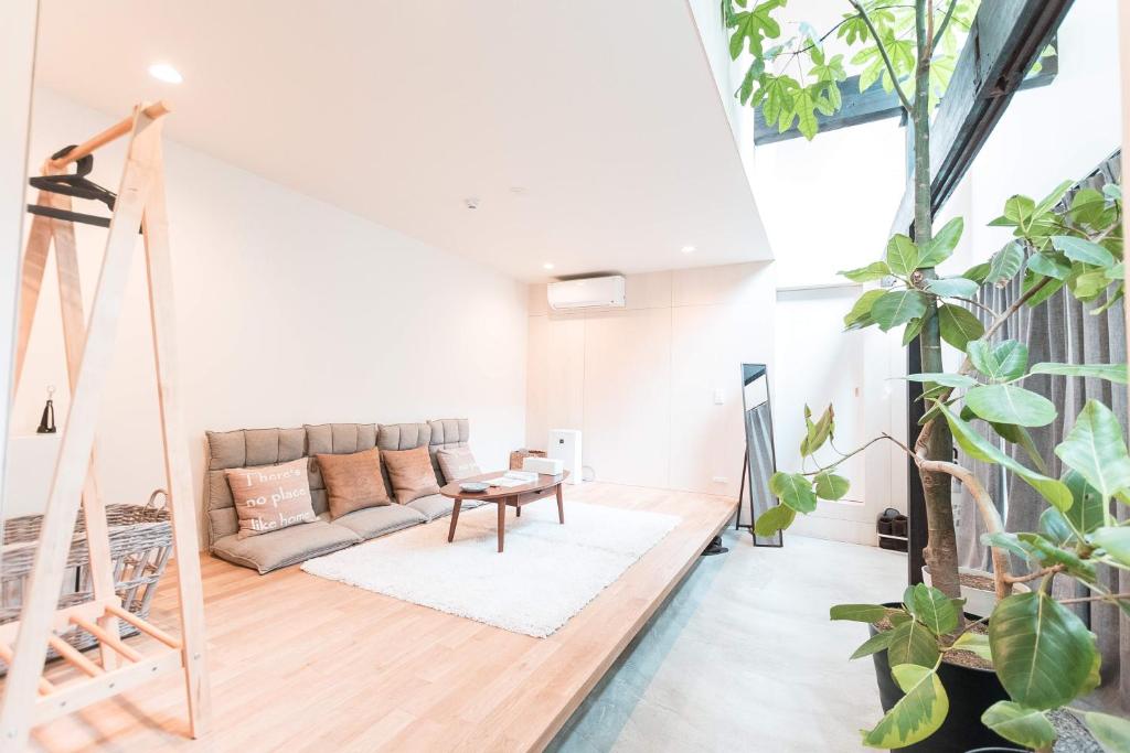 una sala de estar con sofá y muchas plantas en 谷町君 星屋 八尾家 京都清水五条, en Kioto