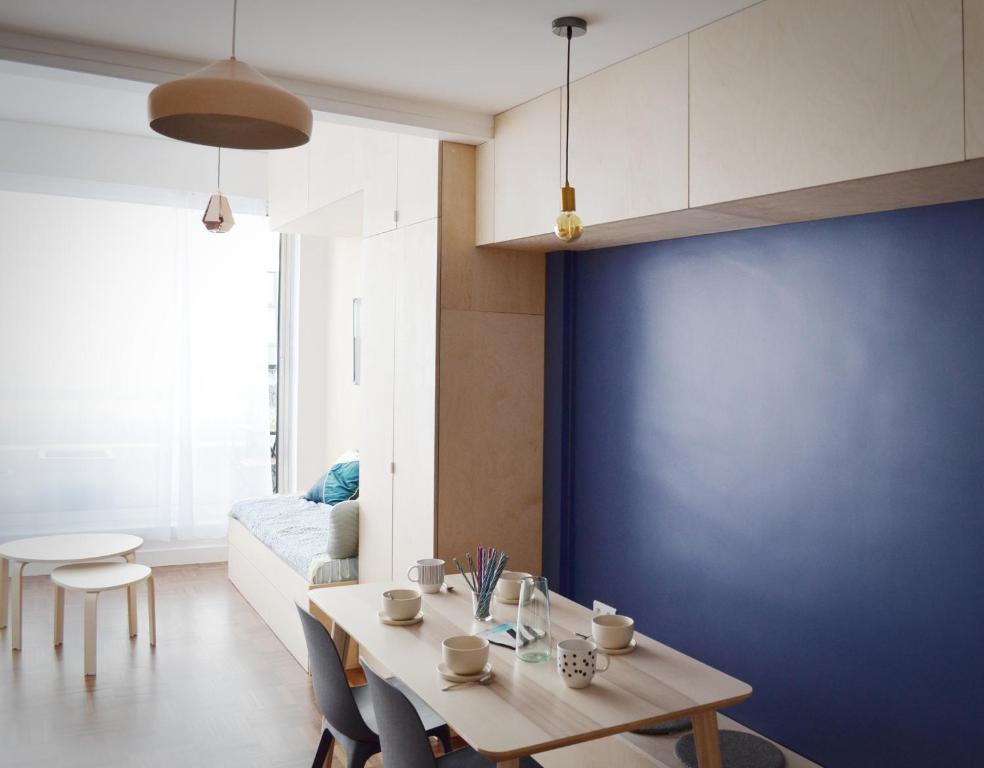 un salon avec une table et un mur bleu dans l'établissement Appartement design avec terrasse, à Paris