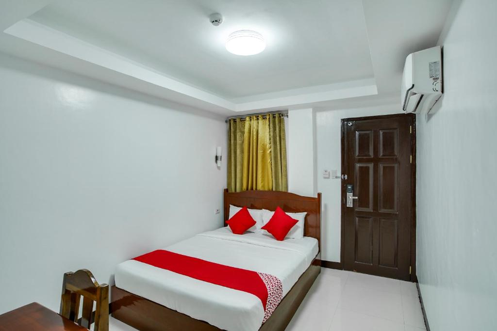 a bedroom with a bed with red pillows and a door at OYO 459 Offshore Hotel in General Santos