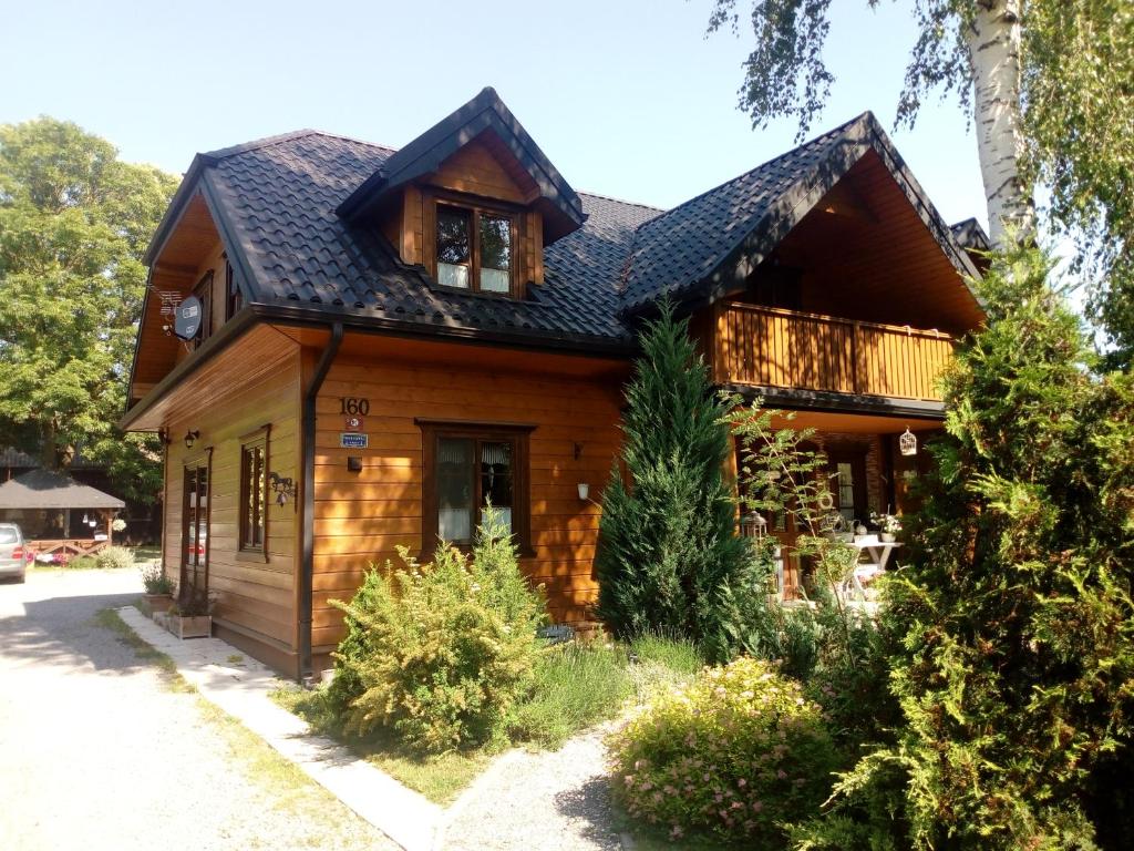ザモシチにあるRoztoczański Dworekの黒屋根の木造家屋