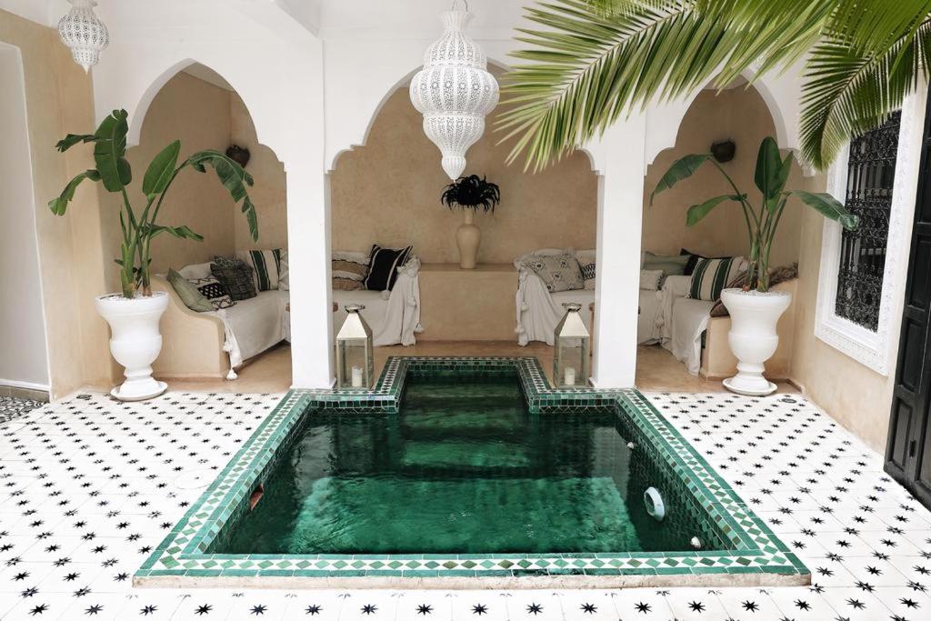 - un salon avec une piscine au milieu d'une maison dans l'établissement Riad SHIRAZ, à Marrakech