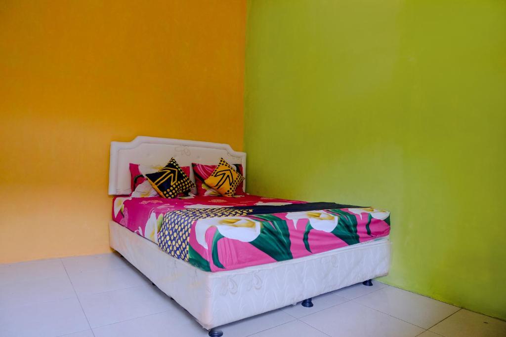 a bedroom with a bed with colorful walls at OYO 1773 Ilyasa Family in Madiun