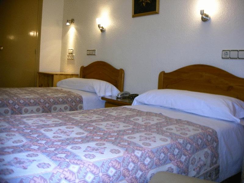 a hotel room with two beds in a room at Hotel La Parra in Archena