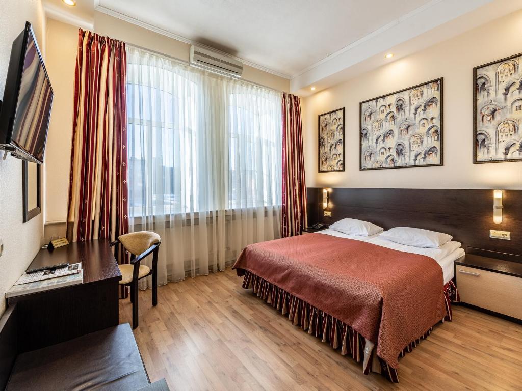 a hotel room with a bed and a large window at Vintage Hotel in Saint Petersburg