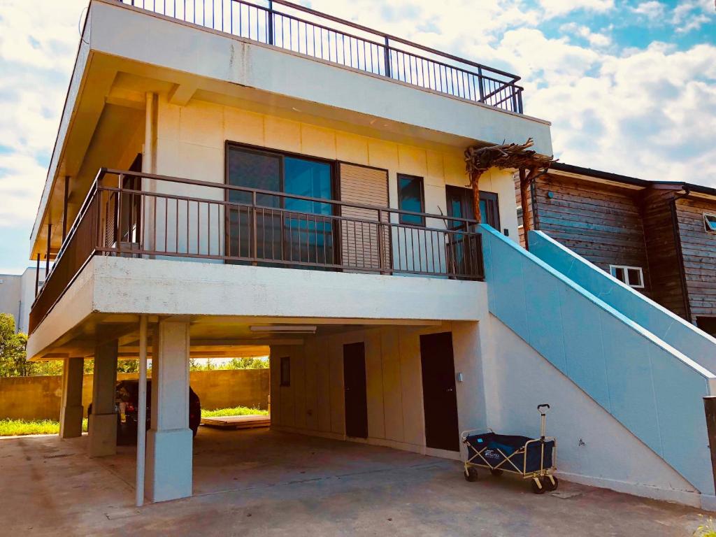 a building with a balcony and a staircase on it at 一棟貸しの海宿 Kamakura SUN&BREEZE in Kamakura
