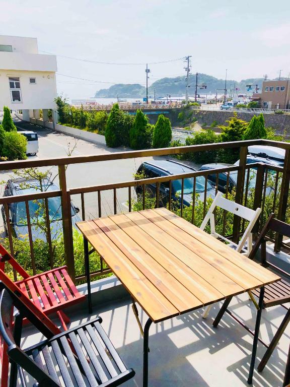 a wooden table and chairs on a balcony at 一棟貸しの海宿 Kamakura SUN&BREEZE in Kamakura