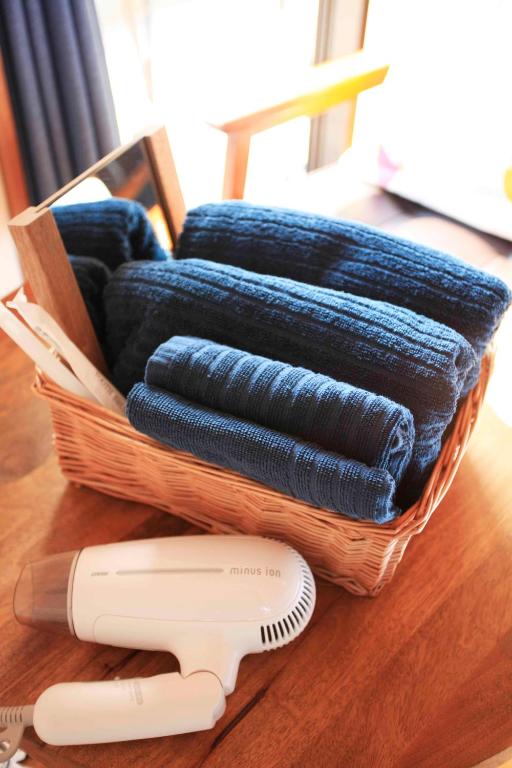 a basket with blue towels and a hair dryer on a table at 一棟貸しの海宿 Kamakura SUN&BREEZE in Kamakura