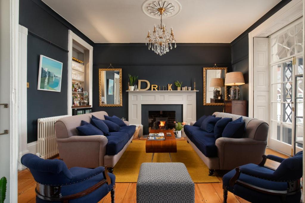 a living room with blue furniture and a fireplace at Dorset House in Lyme Regis