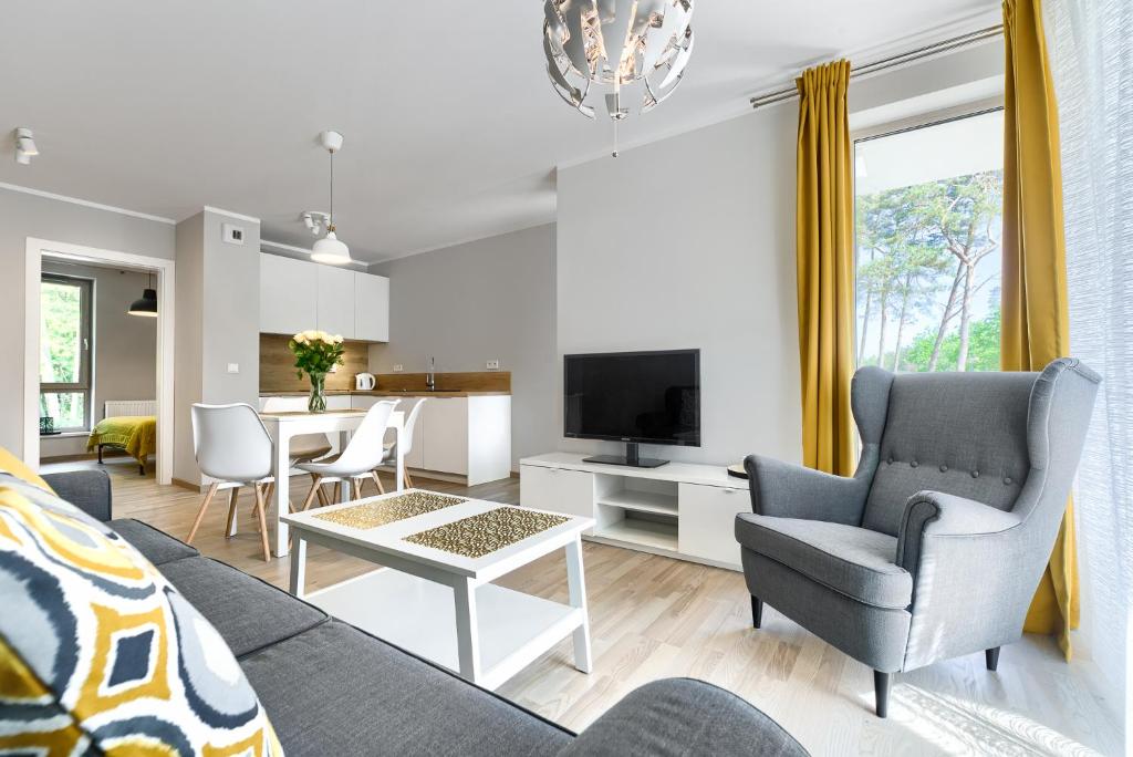 un soggiorno con divano, sedie e tavolo di Apartament Bursztynowy Rezydencja Park a Mielno