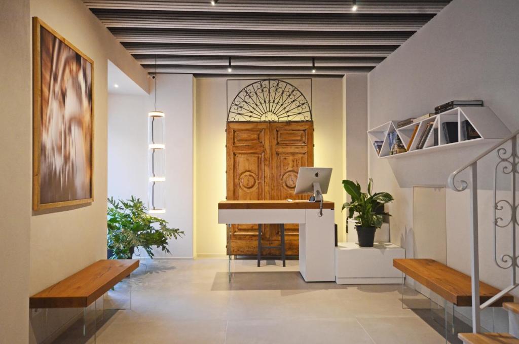 a hallway with a wooden door and benches at Albergo Centrale in Lamezia Terme