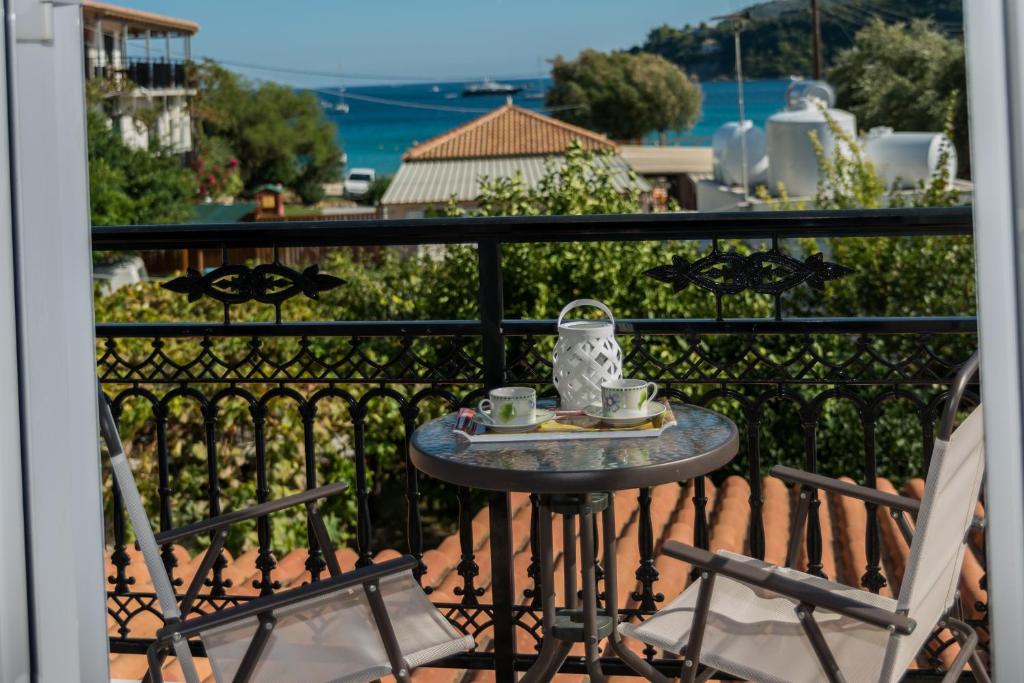 a table with two chairs and a tea set on a balcony at Bratis Apartments in Keri